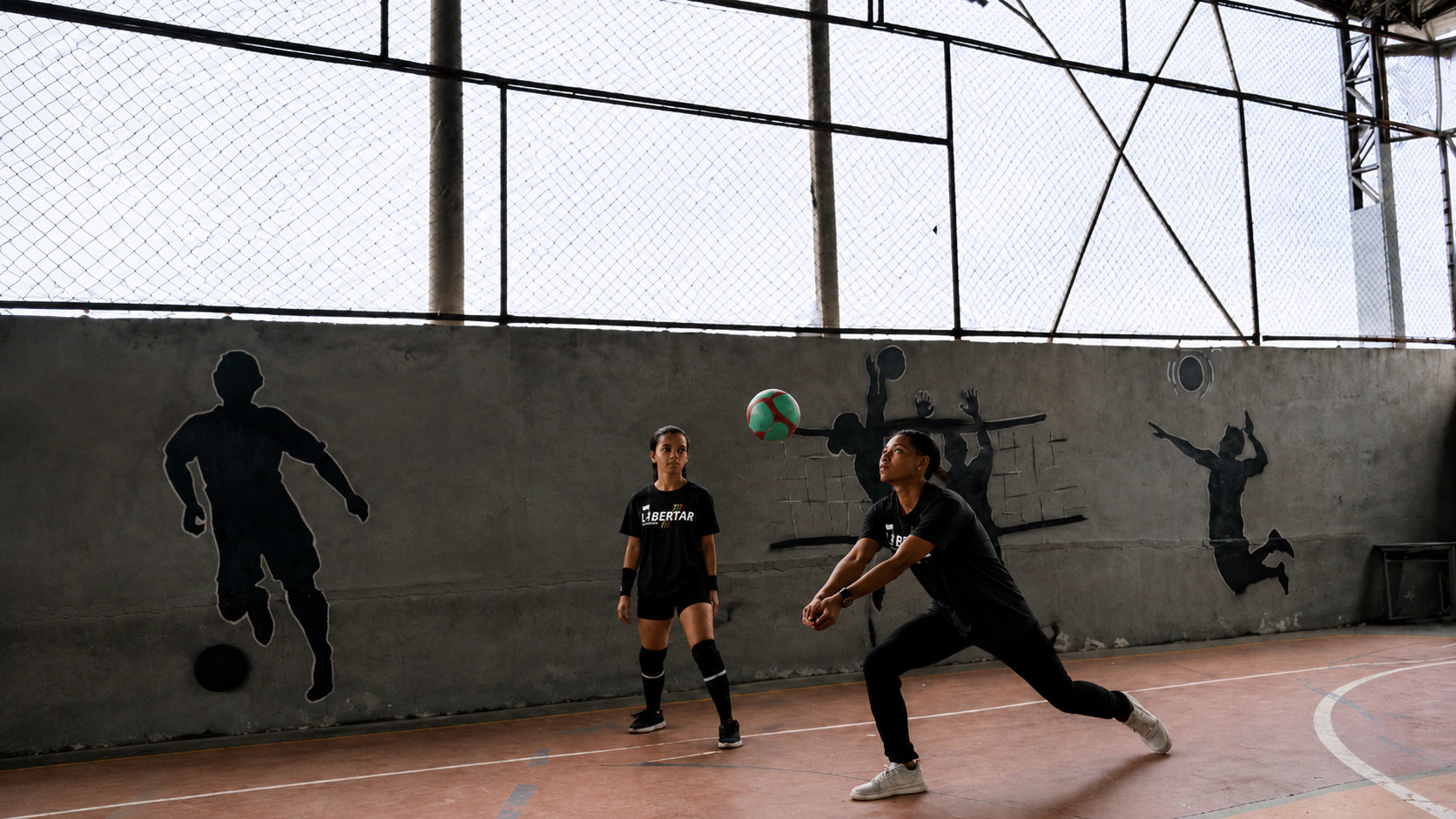 Atletas do Desportivo Libertar executando manchete e recepção durante o jogo